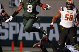 Michigan State safety Montae Nicholson (9) leaps over Maryland quarterback Caleb Rowe, bottom right, while returning an interception as Maryland's Damian Prince (58) pursues during the fourth quarter of an NCAA college football game, Saturday, Nov. 14, 2015, in East Lansing, Mich. (AP Photo/Al Goldis)