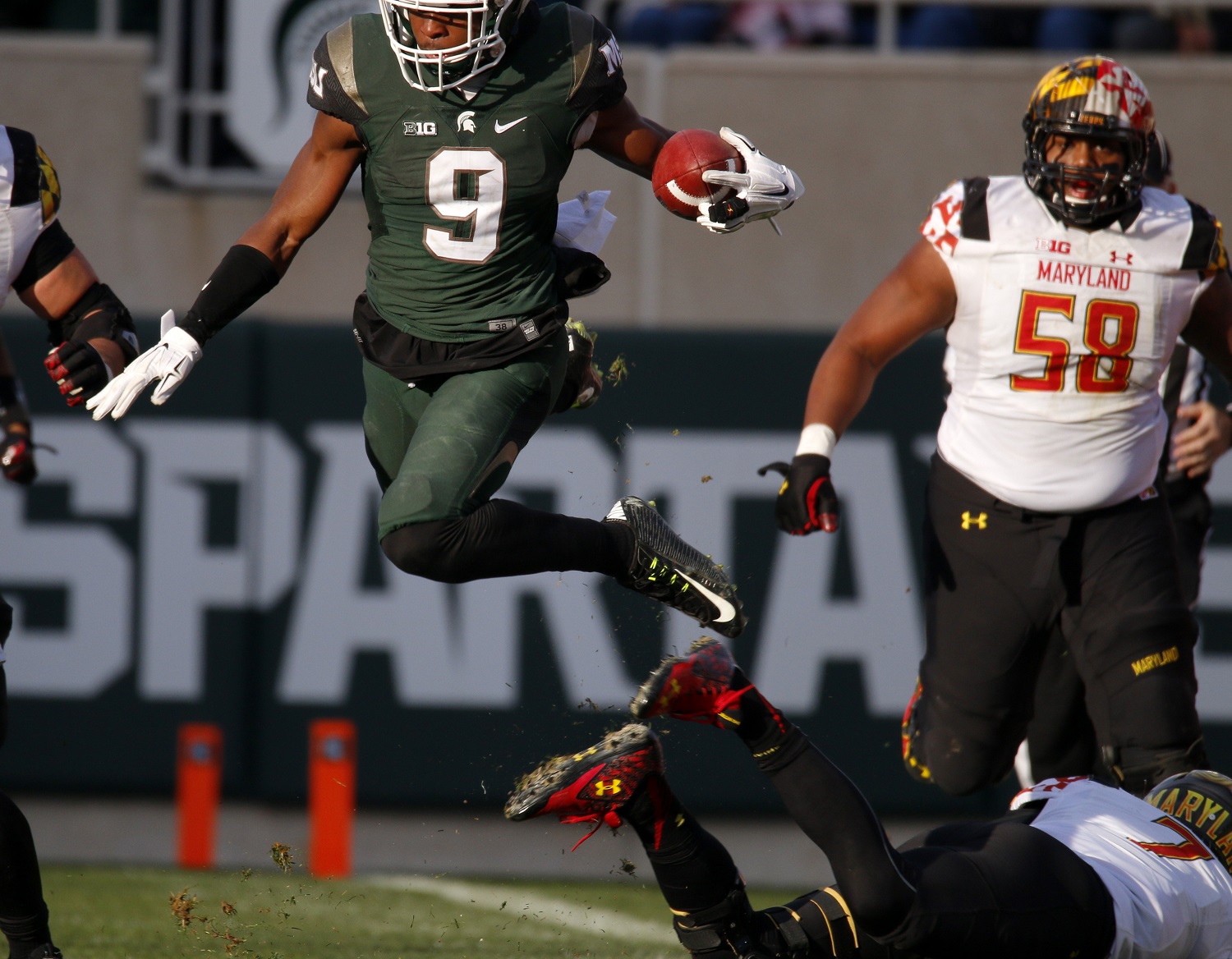 Michigan State safety Montae Nicholson (9) leaps over Maryland quarterback Caleb Rowe, bottom right, while returning an interception as Maryland's Damian Prince (58) pursues during the fourth quarter of an NCAA college football game, Saturday, Nov. 14, 2015, in East Lansing, Mich. (AP Photo/Al Goldis)