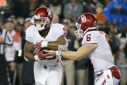 Oklahoma running back Samaje Perine, left, takes the hand off from quarterback Baker Mayfield, right,  in the first half of an NCAA college football game against Baylor on Saturday, Nov. 14, 2015, in Waco, Texas. (AP Photo/Tony Gutierrez)