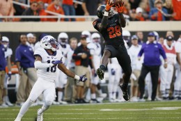 Oklahoma State wide receiver James Washington (28) leaps up for a pass in front of TCU safety Nick Orr (18) in the third quarter of an NCAA college football game in Stillwater, Okla., Saturday, Nov. 7, 2015. Washington took the pass into the end zone for a touchdown and Oklahoma State won 49-29. (AP Photo/Sue Ogrocki)