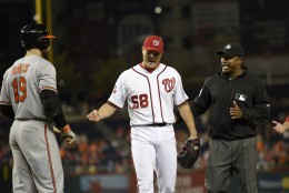 Washington Nationals relief pitcher Jonathan Papelbon (58) reacts next to and umpire Alan Porter, right, during the ninth inning of an interleague baseball game, Wednesday, Sept. 23, 2015, in Washington. Papelbon was ejected for hitting Baltimore Orioles' Manny Machado with a pitch. Also seen is Baltimore Orioles' Chris Davis. The Orioles won 4-3. (AP Photo/Nick Wass)