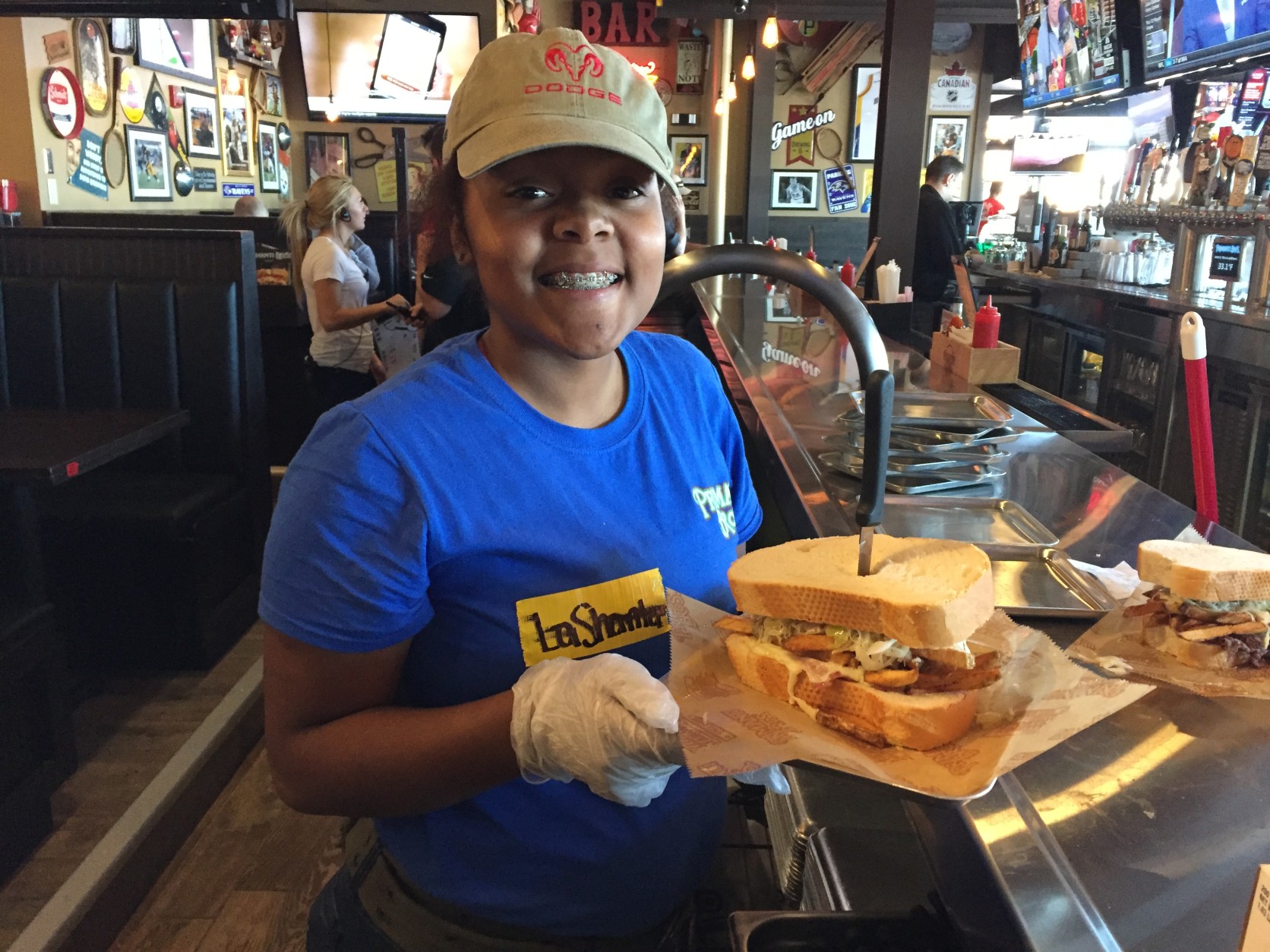 A server happily shows off a famous Primanti Bros. sandwich about to be delivered to a hungry customer. (WTOP/Michelle Basch)