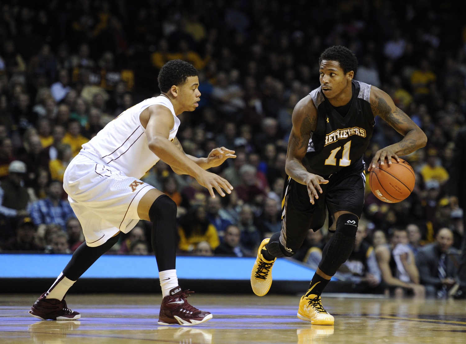 Minnesota guard Nate Mason (2) defends against Maryland-Baltimore County guard/forward Charles Taylor (11) during the first half of an NCAA college basketball game Saturday, Nov. 22, 2014, in Minneapolis. Minnesota won 69-51. (AP Photo/Hannah Foslien)