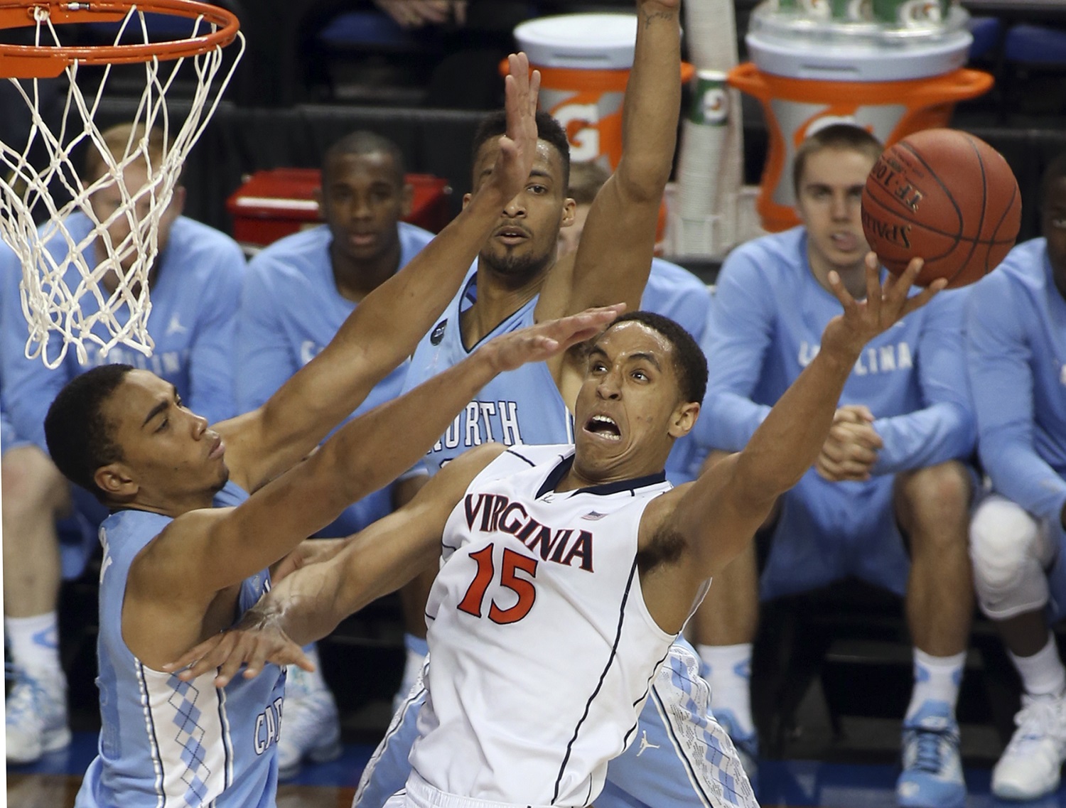 File-This March 13, 2015, file photo shows Virginia's Malcolm Brogdon (15) shooting against North Carolina's Brice Johnson, left, during the first half of an NCAA college basketball game in Greensboro, N.C. The Cavaliers have changed their expectations after consecutive 30-win seasons and ACC regular season titles, but have been ousted from the NCAA tournament in both years by Michigan State. With four seniors in the rotation, this is their last chance to bring Virginia a national championship.(AP Photo/Bob Jordan, File)