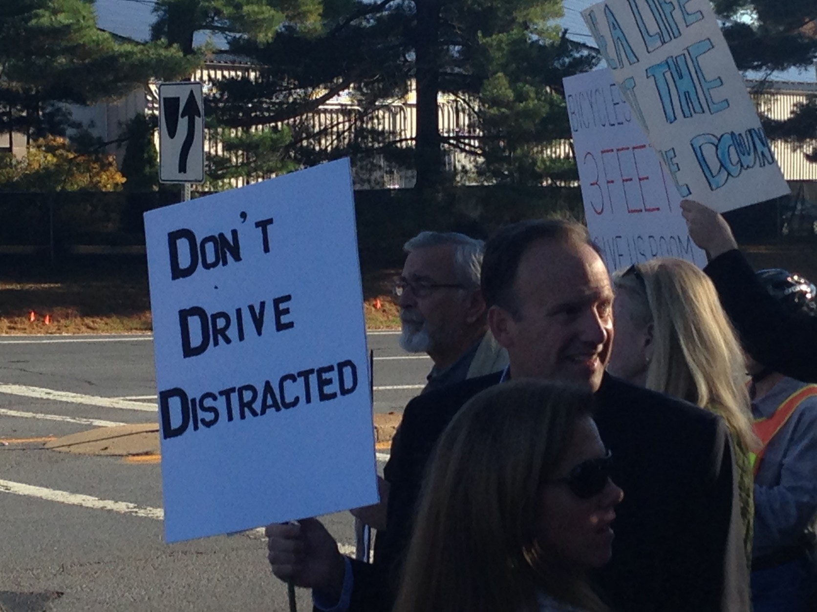 On Tuesday, a few Bethesda residents visited a busy intersection to denounce distracted driving. The residents want motorists to focus on the road, not their cellphones. (WTOP/Jamie Forzato)