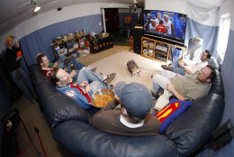 **FOR USE WITH AP LIFESTYLES**    From right, Greg Nuccio, John Otterson, Tom Bruce, Joe Stone, Eirik Thune-Larsen and Fred Wilson sit on a pair of couches to watch college basketball conference finals on a big-screen television while Bill Reeves, back left, looks on while practicing his own shot in the background in Stone's basement turned into a man cave in Thornton, Colo., on Saturday, March 14, 2009. (AP Photo/David Zalubowski)