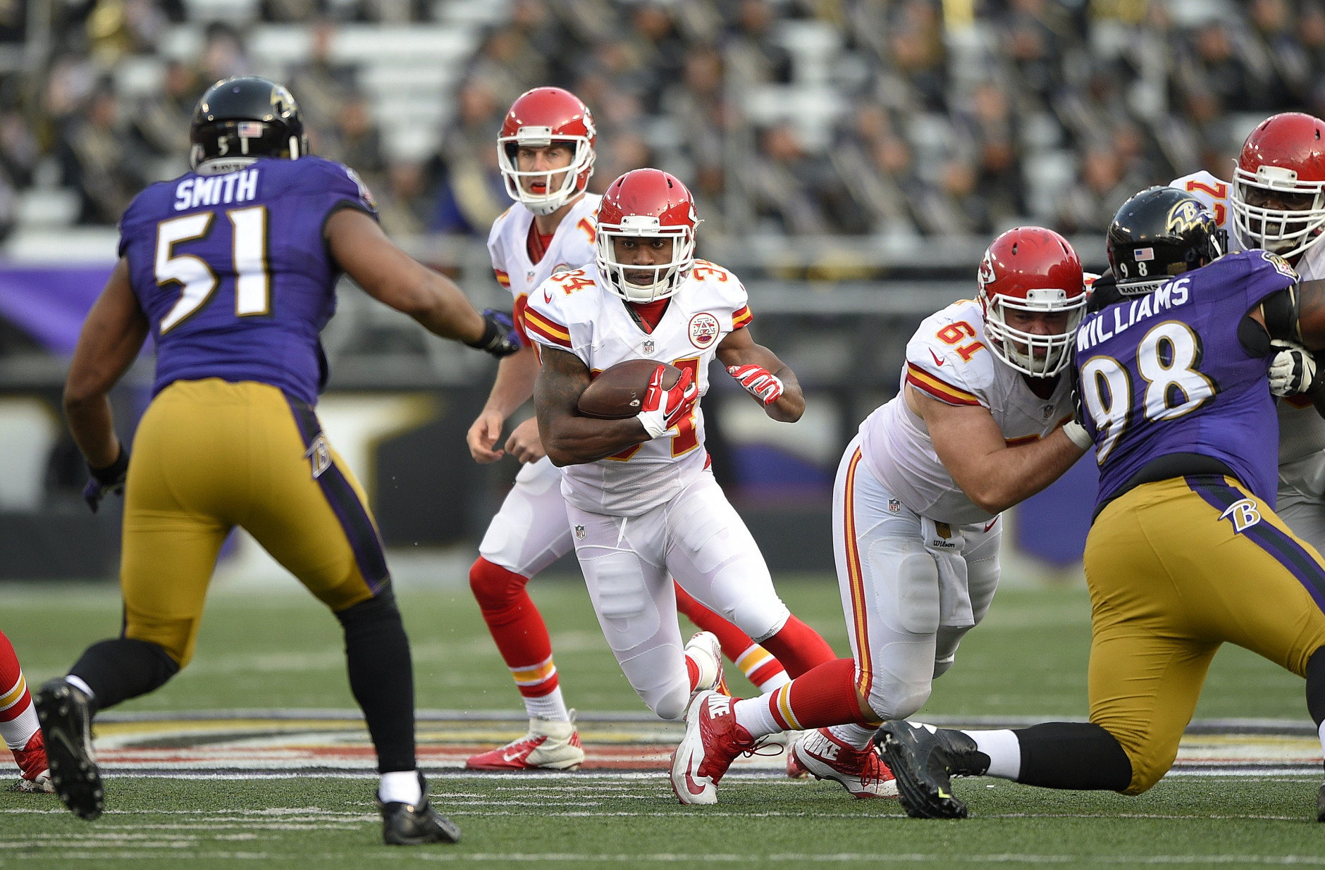 Kansas City Chiefs running back Knile Davis (34) rushes the ball after taking a handoff from Kansas City Chiefs quarterback Alex Smith, back center, in the second half of an NFL football game against the Baltimore Ravens, Sunday, Dec. 20, 2015, in Baltimore. Kansas City won 34-14. (AP Photo/Nick Wass)