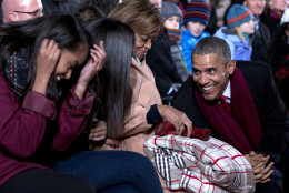 President Barack Obama, leans to talk with his daughters Malia, left, Sasha, second from left, and first lady Michelle Obama's mother Marian Robinson during the National Christmas Tree Lighting ceremony at the Ellipse in Washington, Thursday, Dec. 3, 2015. (AP Photo/Carolyn Kaster)