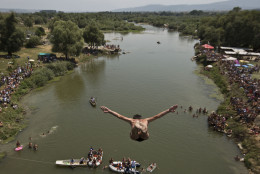 Spectators watch as a diver jumps from the Ura e Shenjte bridge during the traditional annual high diving competition, near the town of Gjakova, 100 kms south of Kosovo capital Pristina, Sunday, July 26, 2015. A total of 27 divers from Kosovo competed diving from a  22 meters high bridge into the Drini i Bardh river. (AP Photo/Visar Kryeziu)