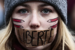 FOR USE AS DESIRED, YEAR END PHOTOS - FILE - A woman has taped her mouth  displaying the word Freedom on the tape as she gathers with several thousand people in solidarity with victims of two terrorist attacks in Paris, one at the office of weekly newspaper Charlie Hebdo and another at a kosher market, in front of the Brandenburg Gate near the French embassy in Berlin, Sunday, Jan. 11, 2015.  (AP Photo/Markus Schreiber, File)