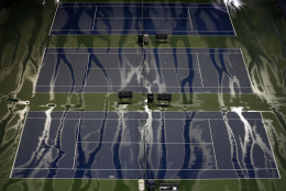 Rain water streaks across practice courts before Roger Federer, of Switzerland, played Novak Djokovic, of Serbia, in the men's championship match of the U.S. Open tennis tournament, Sunday, Sept. 13, 2015, in New York. (AP Photo/Seth Wenig)