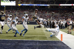 St. Louis Rams running back Todd Gurley, center, scores between Detroit Lions linebacker Josh Bynes, left, and free safety Glover Quin, right, on a 5-yard run during the third quarter of an NFL football game Sunday, Dec. 13, 2015, in St. Louis. (AP Photo/Tom Gannam)
