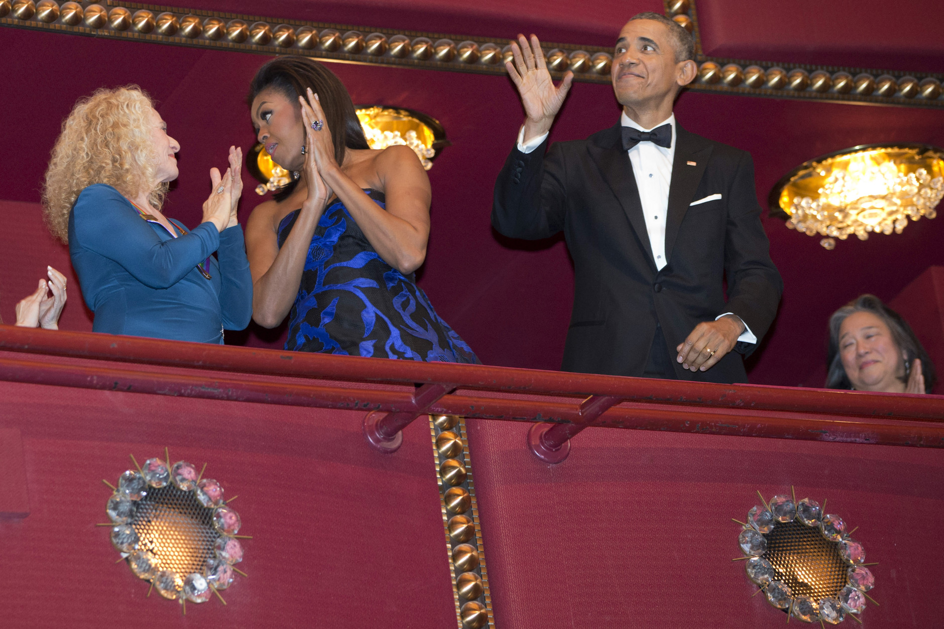 President Barack Obama waves as first lady Michelle Obama speaks to honoree singer-songwriter Carole King, left, as the Obama's arrive to the 2015 Kennedy Center Honors in Washington, after the president made an address to the nation, Sunday, Dec. 6, 2015. (AP Photo/Jacquelyn Martin)