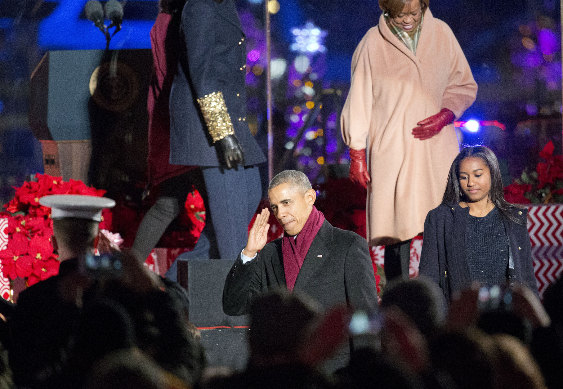 President Barack Obama returns a salute from members of the military as he walks off stage with his daughter Sasha and his mother-in-law Marian Robinson during the National Christmas Tree Lighting ceremony at the Ellipse in Washington, Thursday, Dec. 3, 2015. (AP Photo/Pablo Martinez Monsivais)