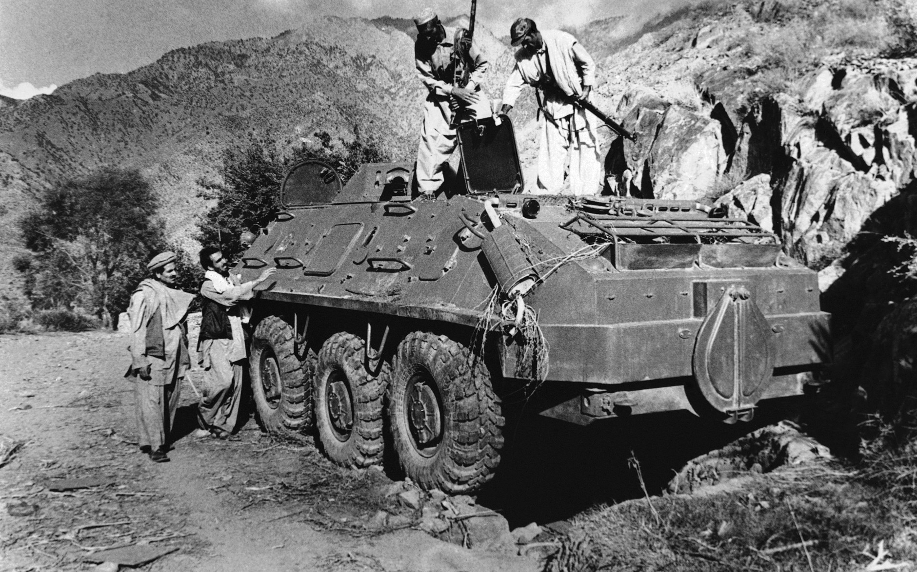 Rebel Muslim fighters inspect a Soviet tank captured in fighting with the Kabul government forces on September near Asmar, Afghanistan on Thursday, Dec. 27, 1979. The Kabul government of Hafizaullah Amin was overthrown by former Deputy Prime Minister Babrak Karmal. (AP Photo/Steve McCurry)