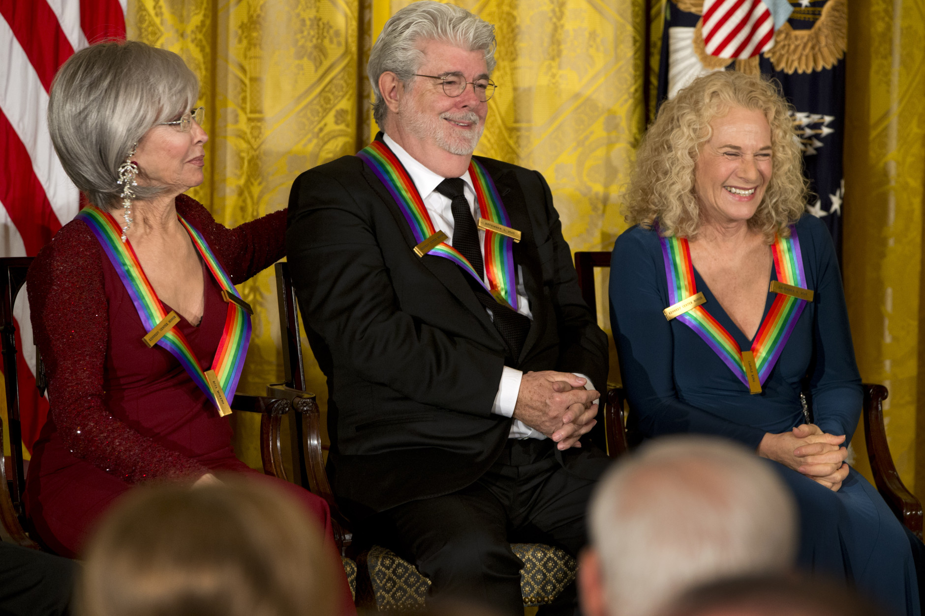 2015 Kennedy Center Honors honorees from left, actress and singer Rita Moreno, filmmaker George Lucas, and singer-songwriter Carole King, react as President Barack Obama speaks about Lucas during the 2015 Kennedy Center Honors reception in the East Room of the White House in Washington, Sunday, Dec. 6, 2015. (AP Photo/Jacquelyn Martin)