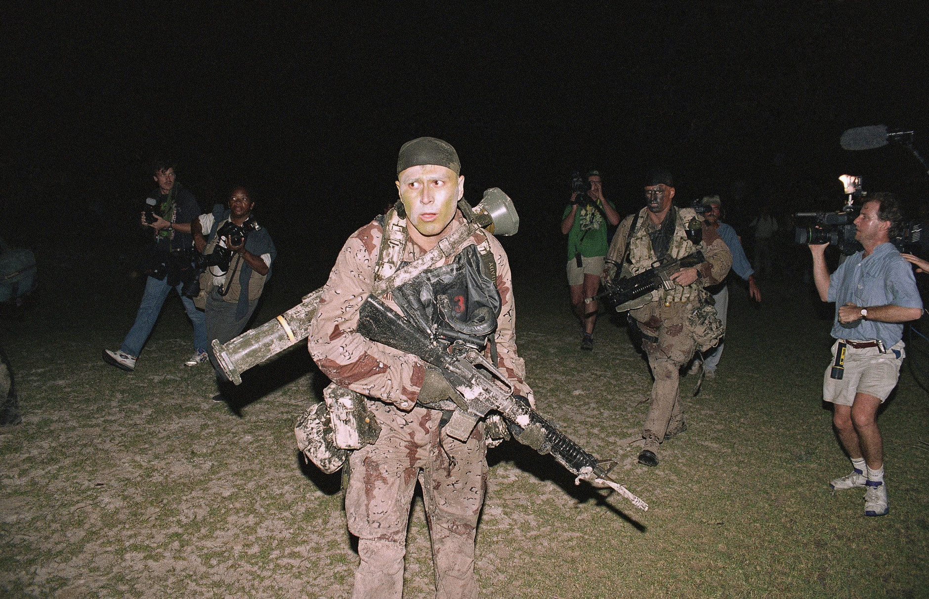 U.S. Marines are pictured running onto the beach while being pursued by photographers and other media during the beginning of Operation Restore Hope, Dec. 9, 1992 in Somalia. (AP Photo/Denis Paquin)