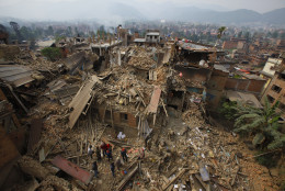 FOR USE AS DESIRED, YEAR END PHOTOS - FILE - Rescue workers remove debris as they search for victims of earthquake in Bhaktapur near Kathmandu, Nepal, Sunday, April 26, 2015. A strong earthquake shook Nepal's capital and the densely populated Kathmandu Valley before noon, causing extensive damage with toppled walls and collapsed buildings. (AP Photo/Niranjan Shrestha, File)