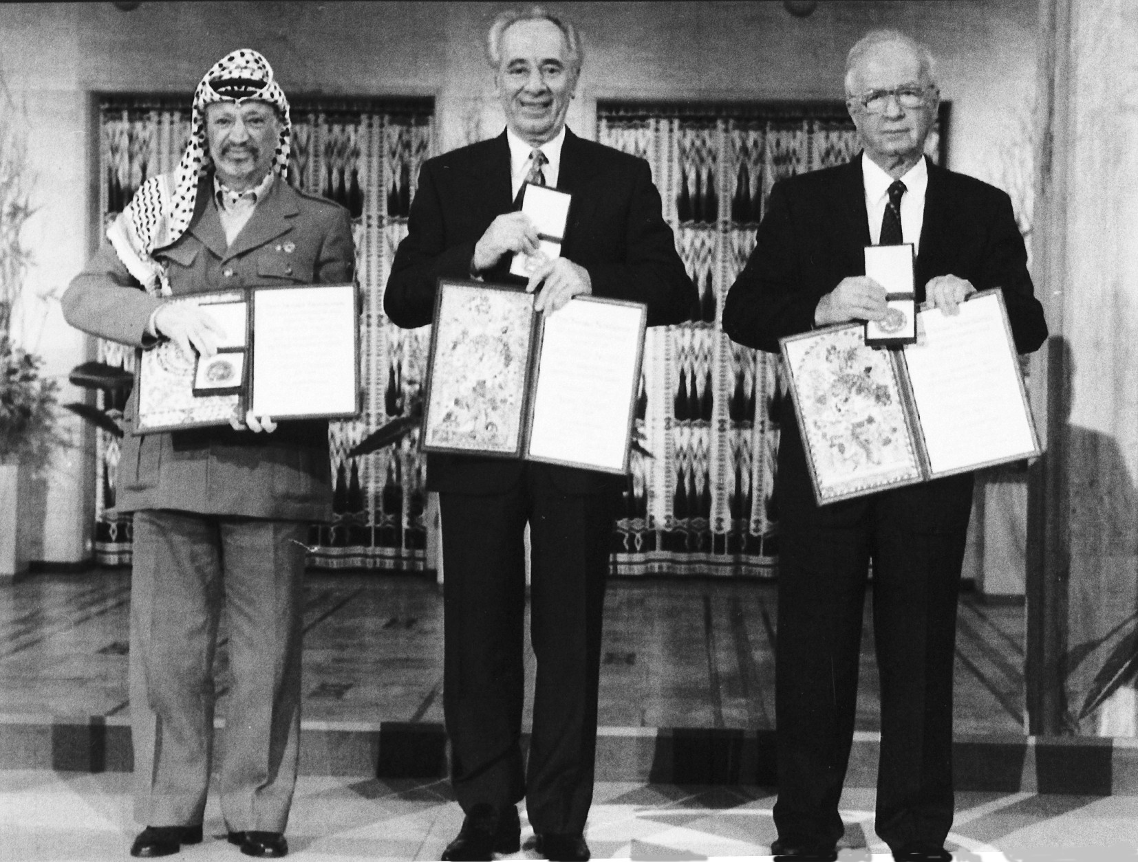 PLO leader Yasser Arafat, left, Israeli Prime Minister Yitzhak Rabin, centre, and Israeli Foreign Minister Shimon Peres pose with their medals and diplomas, after receiving the 1994 Nobel Peace Prize in Oslo's City Hall, Dec. 10, 1994. The three men received the prize for their efforts towards peace in the Middle East. (AP Photo)