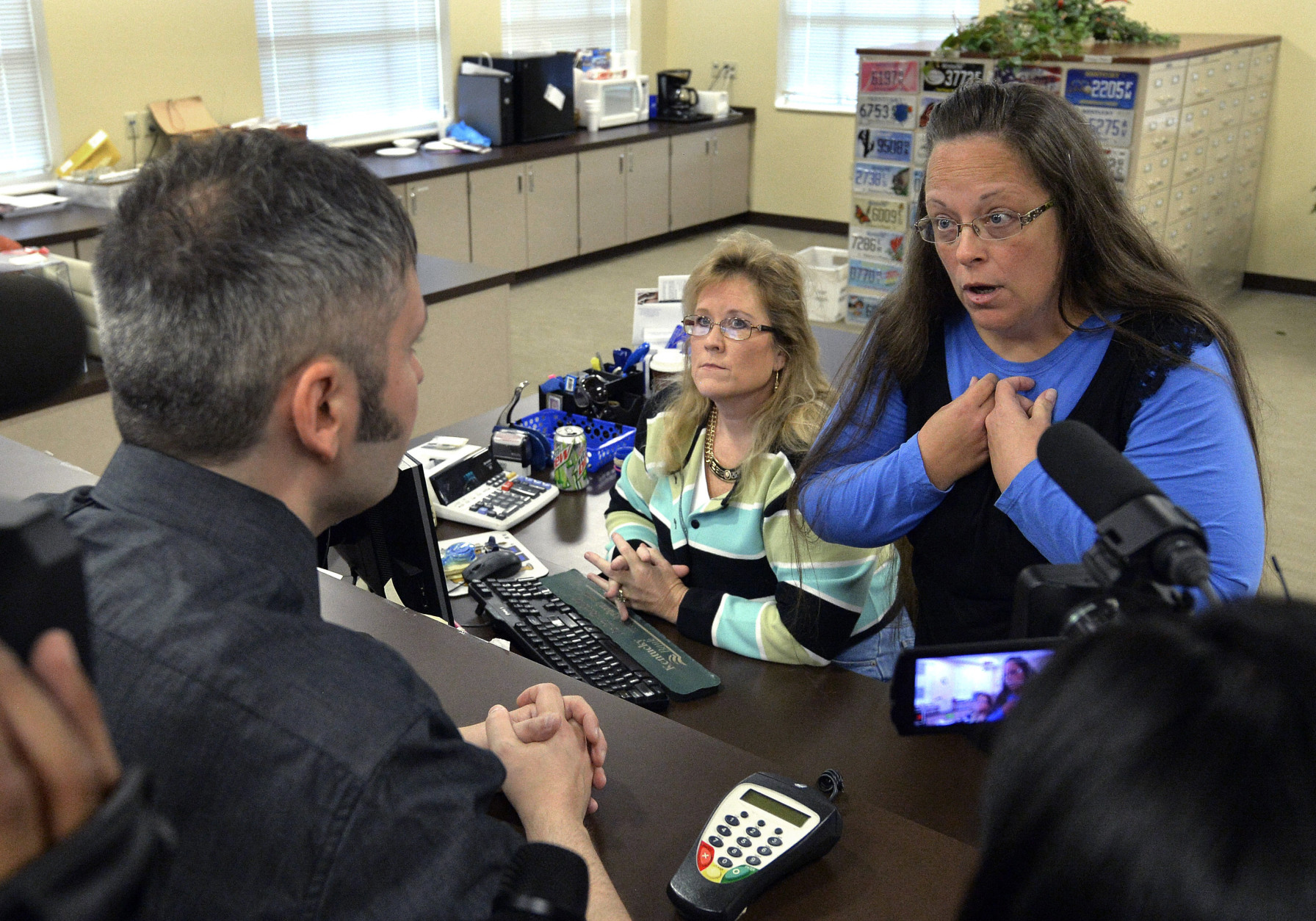 FOR USE AS DESIRED, YEAR END PHOTOS - FILE - Rowan County Clerk Kim Davis, right, talks with David Moore following her office's refusal to issue marriage licenses at the Rowan County Courthouse in Morehead, Ky., Tuesday, Sept. 1, 2015. Although her appeal to the U.S. Supreme Court was denied, Davis still refused to issue marriage licenses. (AP Photo/Timothy D. Easley, File)