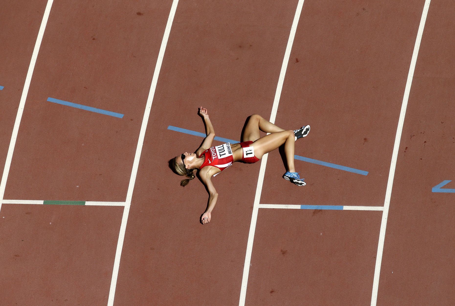 United States' Nicole Tully lays on the track after completing a round one heat of the women's 5000m at the World Athletics Championships at the Bird's Nest stadium in Beijing, Thursday, Aug. 27, 2015.   (AP Photo/Wong Maye-E)