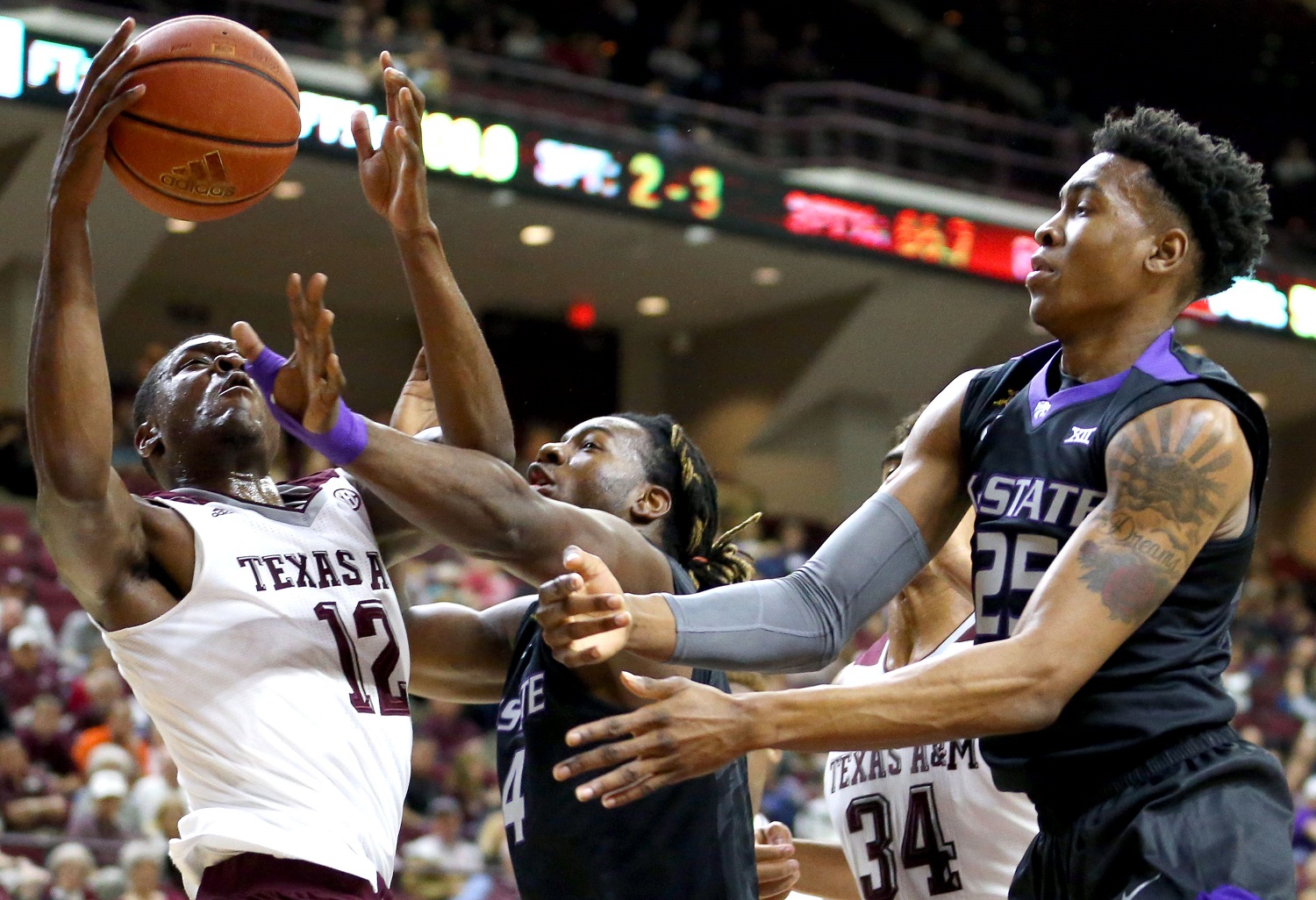 In this photo provided by Sam Craft, Texas A&amp;M's Jalen Jones (12) fights for a rebound against Kansas State's D.J. Johnson (4) and Wesley Iwundu (25) during an NCAA college basketball game on Saturday, Dec. 12, 2015, in College Station Texas. (Sam Craft via AP)