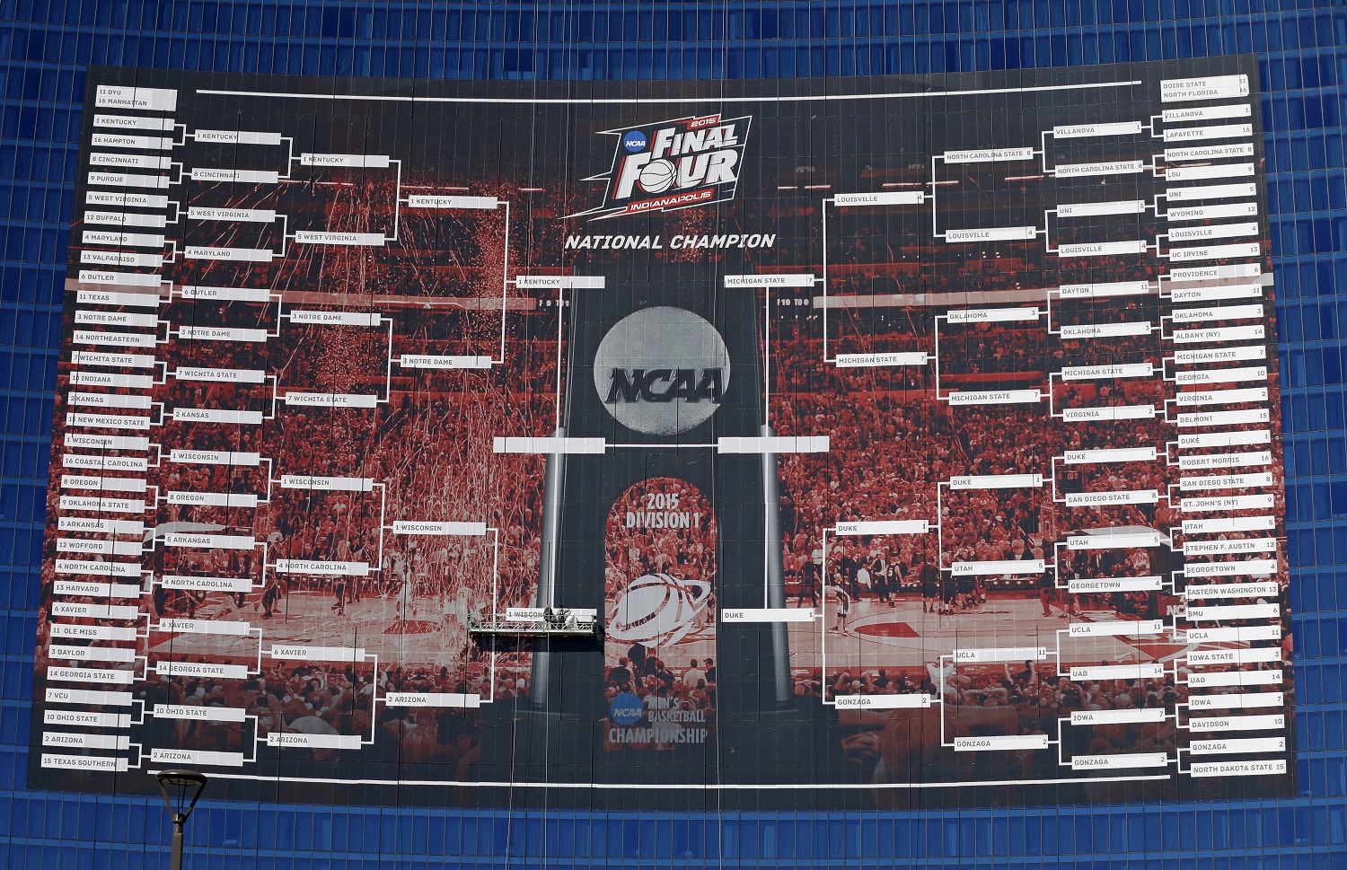 Workers complete the Final Four match ups on a 2015 NCAA Division I Mens Basketball Championship bracket that is displayed on the side of the JW Marriott, in Indianapolis, Monday, March 30, 2015. (AP Photo/Michael Conroy)