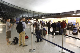 United Airlines passengers wait at the ticket counter of Washington Dulles International Airport in Chantilly, Va., Saturday, June 18, 2011. United Airlines computers crashed at at about 8:15 p.m. EDT interrupting departures and reservations and disrupting the airline's websites. (AP Photo/Luis M. Alvarez)