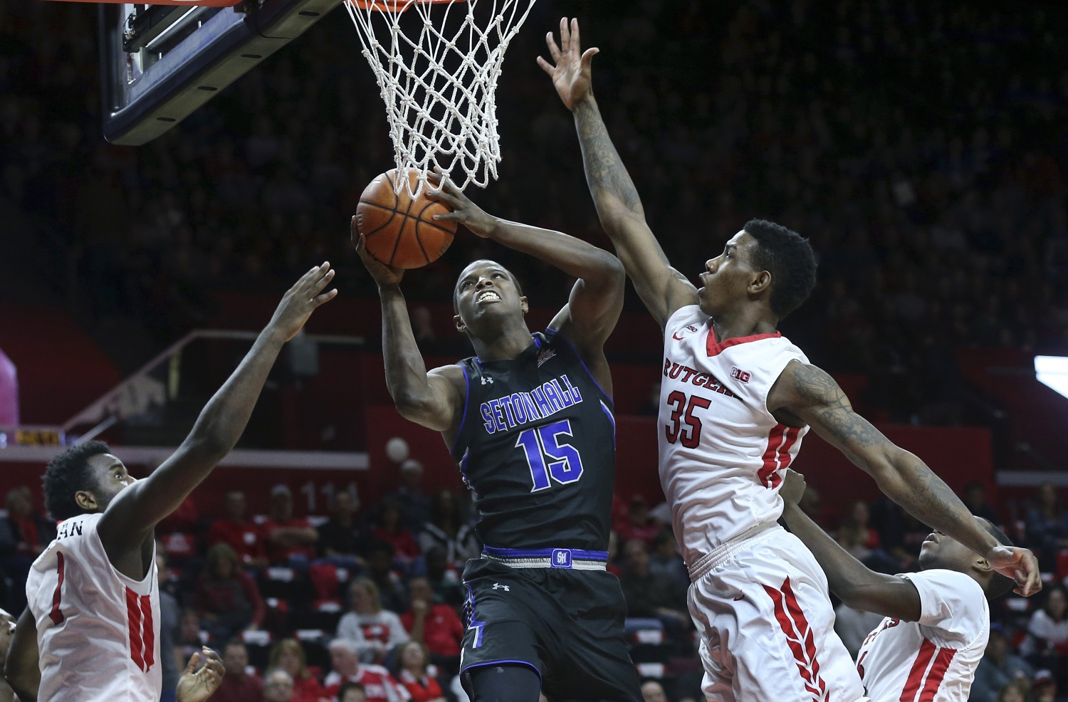 Seton Hall forward Isaiah Whitehead (15) takes a shot as he splits Rutgers defenders Greg Lewis (35) and D.J. Foreman (1) during the first half of an NCAA college basketball game Saturday, Dec. 5, 2015, in Piscataway, N.J. (AP Photo/Mel Evans)