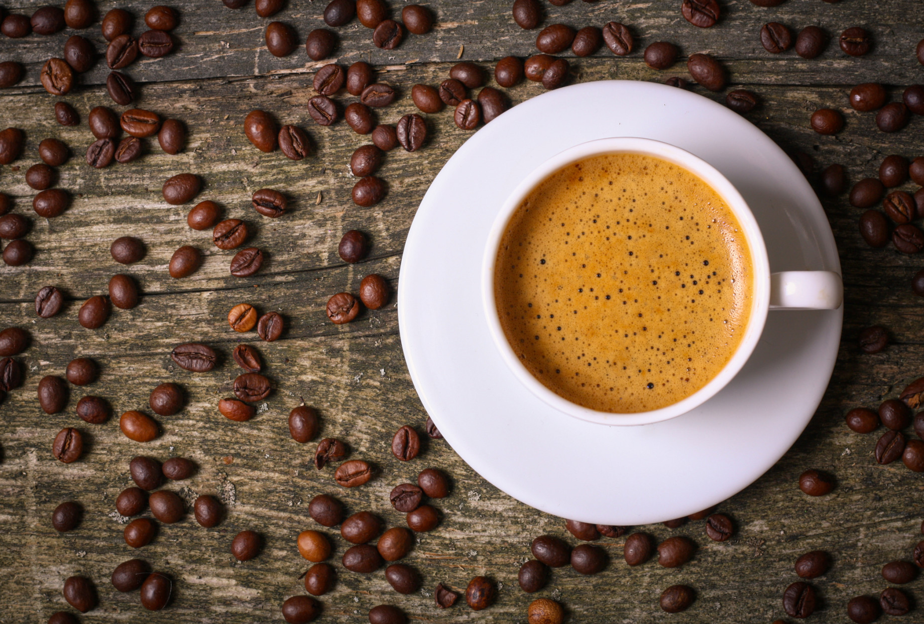 hot cup of coffee and  beans on  old wooden table