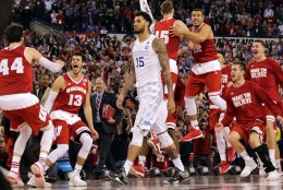 Wisconsin bench celebrates as Kentucky's Willie Cauley-Stein walks off after the NCAA Final Four tournament college basketball semifinal game Saturday, April 4, 2015, in Indianapolis. Wisconsin won 71-64. (AP Photo/David J. Phillip)