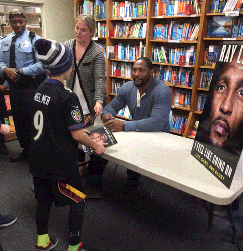 Adam Helmer gets his book signed by Ray Lewis at Politics and Prose in D.C. Tuesday. (WTOP/Molly Welton) 