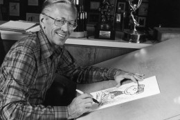 1978:  Portrait of American cartoonist Charles M Schulz (1922 - 2001), creator of the 'Peanuts' comic strip, sitting at his studio drawing table with a picture of his character Charlie Brown and some awards behind him. Schulz created the comic strip in 1950.  (Photo by CBS Photo Archive/Getty Images)