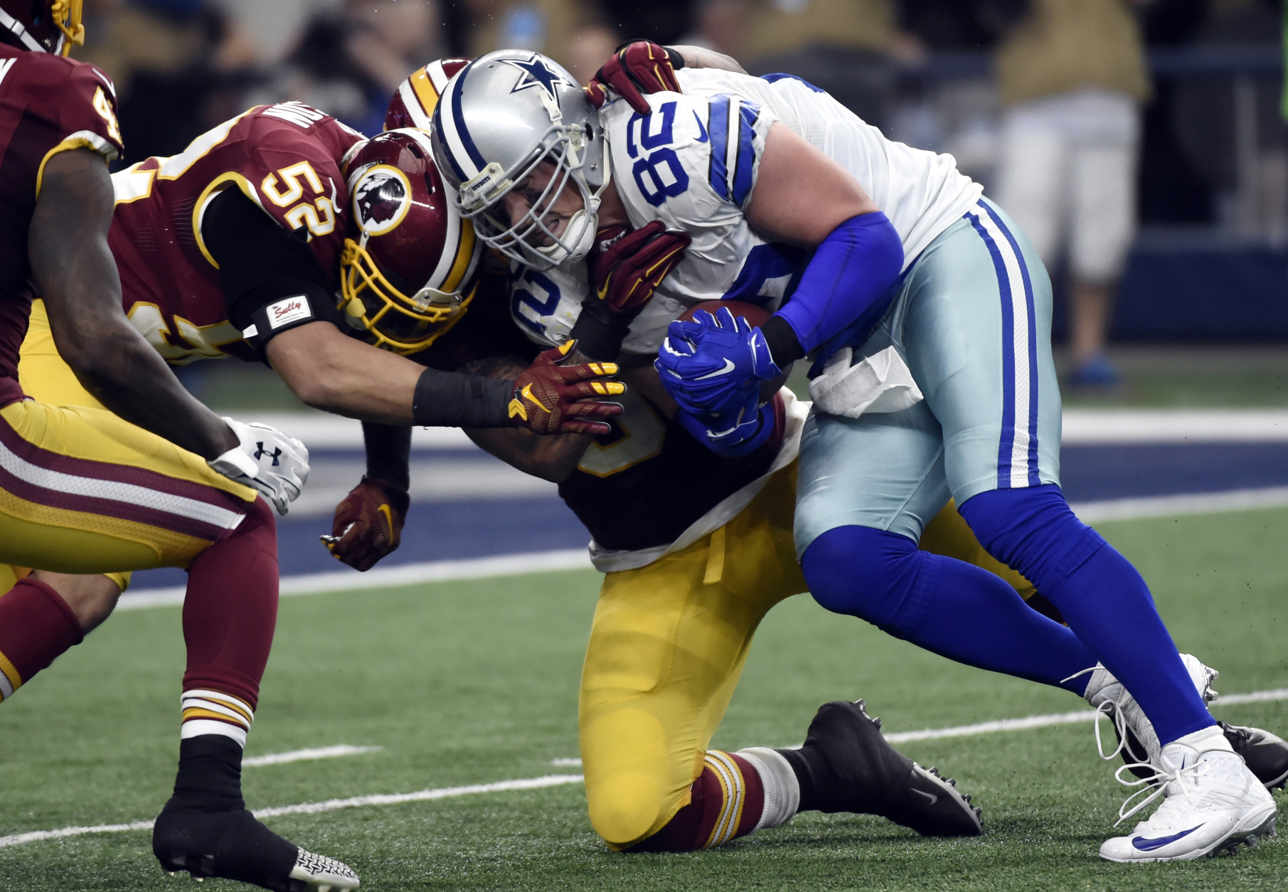 Washington Redskins' Keenan Robinson (52) and Mason Foster, rear, combine to stop Dallas Cowboys' Jason Witten (82) as Witten fights for extra yardage after making a catch in the first half of an NFL football game, Sunday, Jan. 3, 2016, in Arlington, Texas. (AP Photo/Michael Ainsworth)