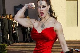 FILE - In this Nov. 16, 2003 file photo, Joanie Laurer, former pro wrestler known as Chyna, flexes her bicep as she arrives at the 31st annual American Music Awards, in Los Angeles. Chyna, the WWE star who became one of the best known and most popular female professional wrestlers in history in the late 1990s, has died at age 45. Los Angeles County coroners Lt. Larry Dietz says Chyna, whose real name is Joan Marie Laurer, was found dead in Redondo Beach on Wednesday, April 20, 2016. (AP Photo/Kevork Djansezian, File)