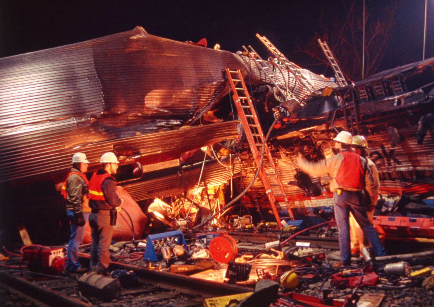 Workmen survey the damage from the collision between an Amtrak passenger train and three Conrail diesel engines, in Chase Md., on Jan 4, 1987. Fifteen people were killed and more than 170 injured in the collision. (AP Photo/Applewhite)