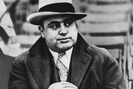 Al Capone is photographed at a football game in Chicago on Jan. 19, 1931.  Everywhere he went, people recognized him.  Capone always wore a loud tie, a bent brim fedora hat and camel's hair polo coat and always had an entourage of bodyguards.  (AP Photo)