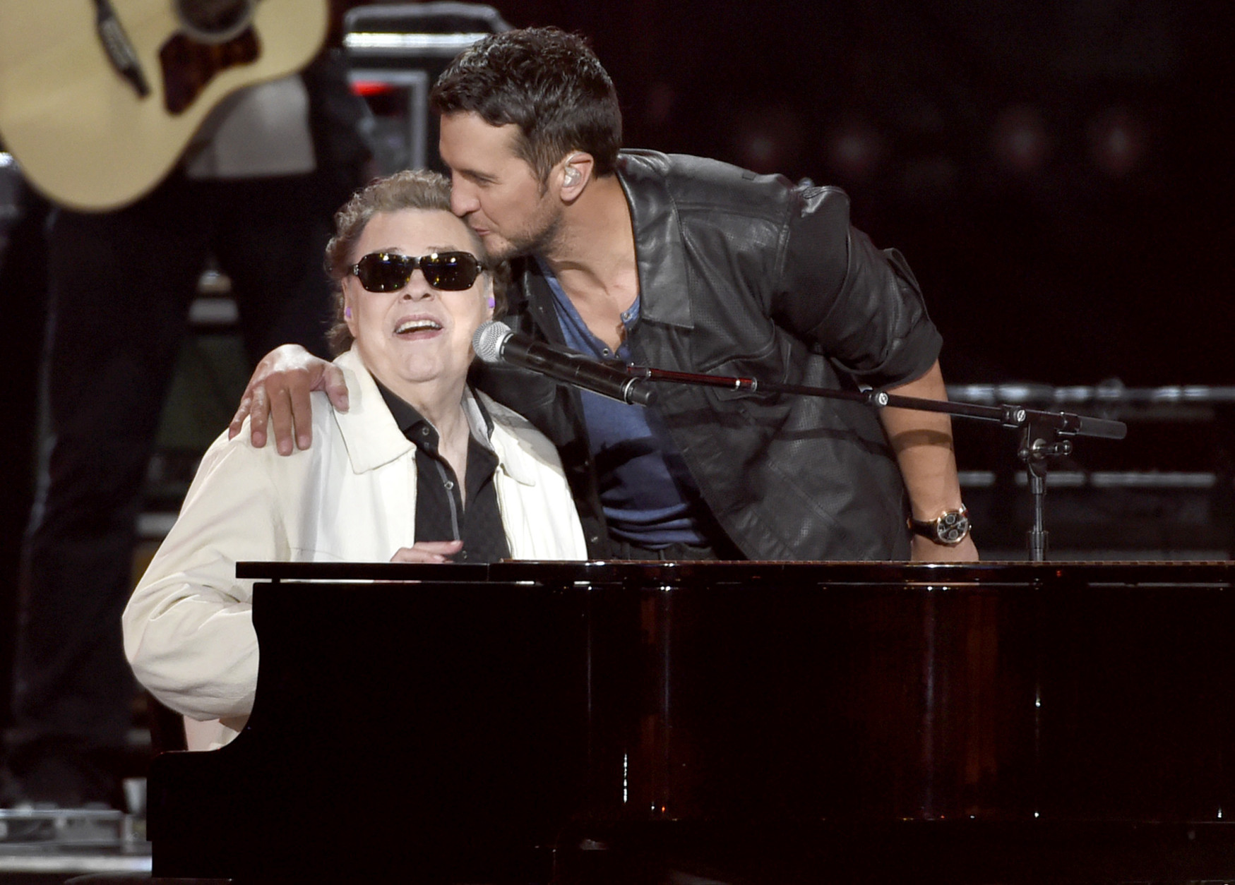 Luke Bryan, right, kisses Ronnie Milsap as they perform at ACM Presents Superstar Duets at Globe Life Park on Friday, April 17, 2015, in Arlington, Texas. (Photo by Chris Pizzello/Invision/AP)