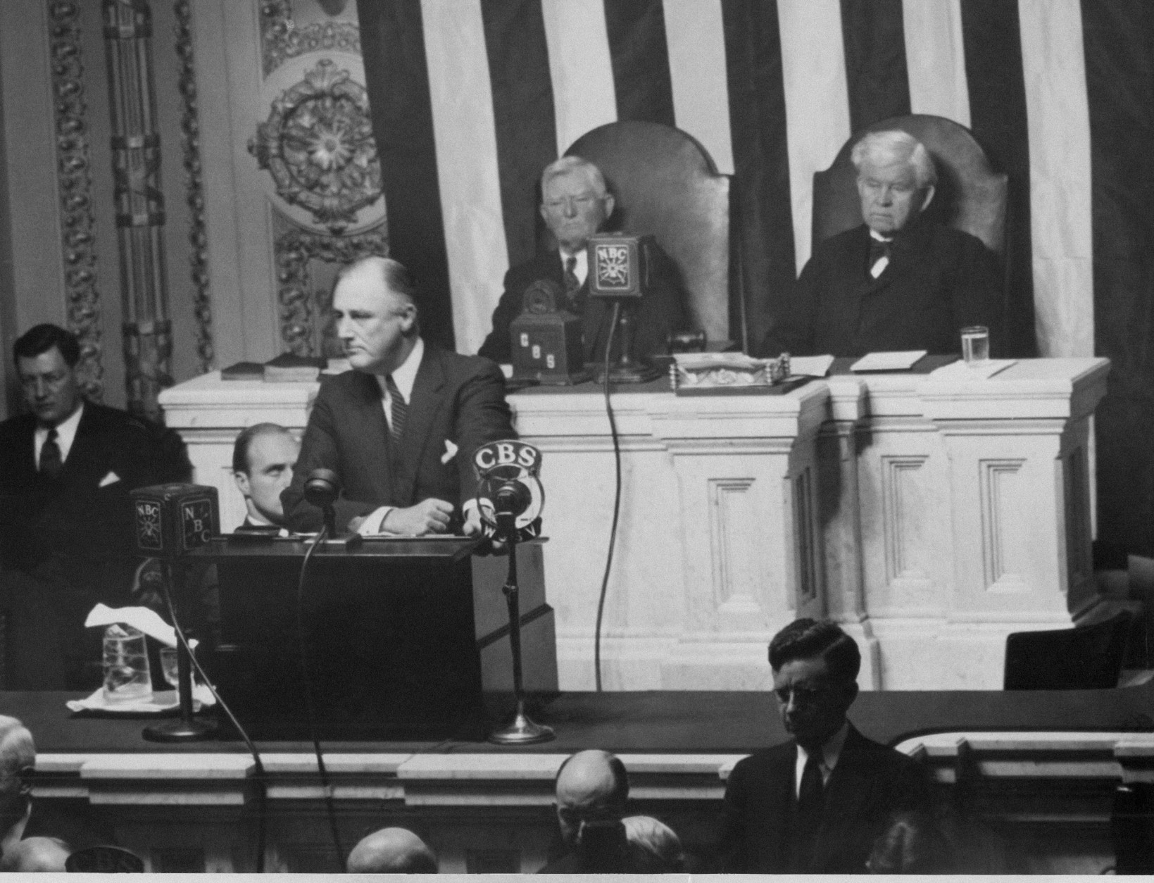 President Franklin Roosevelt delivering his annual message on the State of the Union to a session of the Senate and House in the House chamber on Jan. 3, 1934 behind him (left to right) are Vice President John Garner and Speaker Henry Rainey. (AP Photo)
