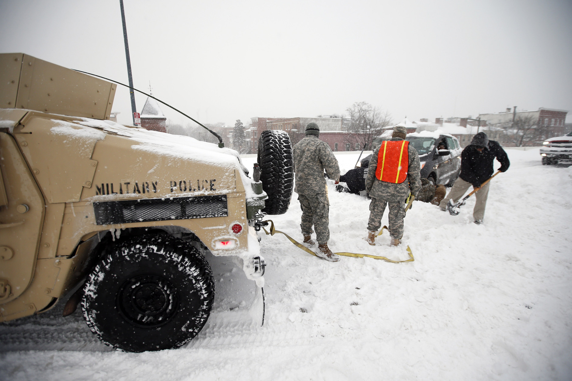 Soldiers with the 275th Military Police company, and a Washington Firefighter, in a Humvee, assist a stranded motorist in the snow on I-395, Saturday, Jan. 23, 2016 in Washington. (AP Photo/Alex Brandon)