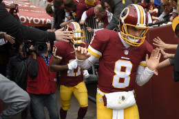 Washington Redskins quarterback Kirk Cousins (8) runs on to the fields for the worm up period before an NFL wild card playoff football game against the Green Bay Packers in Landover, Md., Sunday, Jan. 10, 2016. (AP Photo/Nick Wass)