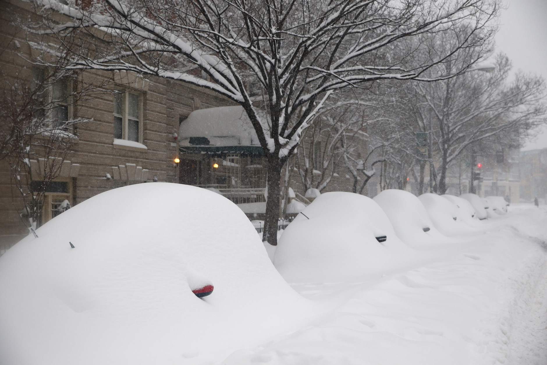 Parked cars are almost completely covered by the snow, Saturday, Jan. 23, 2016 in Washington. A blizzard with hurricane-force winds brought much of the East Coast to a standstill Saturday, dumping as much as 3 feet of snow, stranding tens of thousands of travelers and shutting down the nation's capital and its largest city. (AP Photo/Alex Brandon)