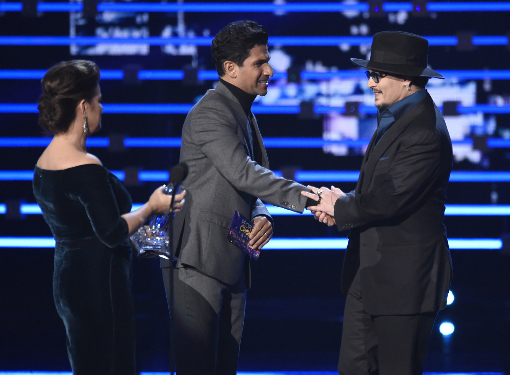 Marcia Gay Harden, left, and Raza Jaffrey present the award for favorite dramatic movie actor to Johnny Depp for "Black Mass" at the People's Choice Awards at the Microsoft Theater on Wednesday, Jan. 6, 2016, in Los Angeles. (Photo by Chris Pizzello/Invision/AP)