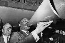 Dr. Martin Luther King Jr. uses a megaphone to address demonstrators assembled at the courthouse in Montgomery, Ala. after a meeting with Sheriff Mac Butler, left, and other public officials. (AP Photo/File)