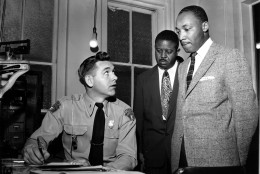The Rev. Martin Luther King Jr., right, accompanied by Rev. Ralph D. Abernathy, center, is booked by city police Lt. D.H. Lackey in Montgomery, Ala., on Feb. 23, 1956.  The civil rights leaders are arrested on indictments turned by the Grand Jury in the bus boycott.  (AP Photo/Gene Herrick)