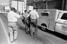 A police officer holds the Rev. Martin Luther King Jr. by his belt as he leads him to the paddy wagon, following arrest at an anti-segregation protest in downtown Birmingham, Ala., on April 13, 1963. An unidentified cameraman is documenting the scene.  (AP Photo)