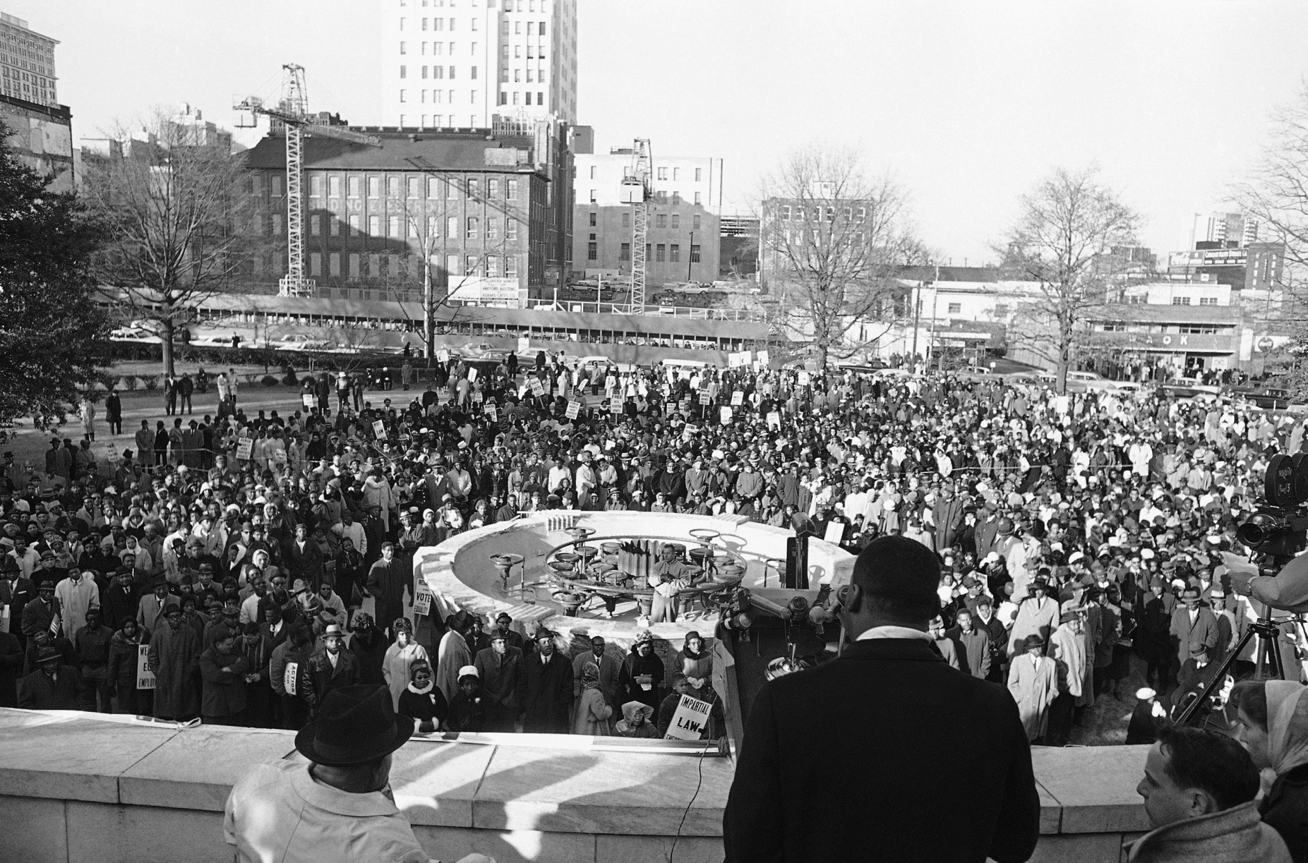 Dr. Martin Luther King Jr., President of the Southern Christian Leadership Conference, is heavily guarded as he speaks to an estimated crowd of 2,500 who braved freezing weather to attend an anti-segregation rally in downtown Hurt Park in Atlanta Sunday, Dec. 16, 1963. Police said the integration leaders life had not been threatened, but the officers were a precautionary measure. (AP Photo/Horace Cort)