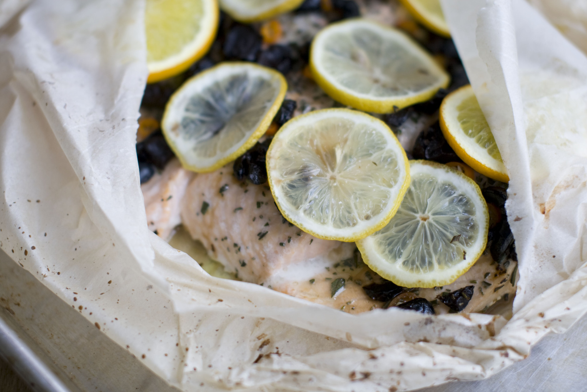 This Dec. 2, 2013 photo shows salmon baked in a bag with citrus, olive and chilies in Concord, N.H. The bag keeps the flavor and moisture trapped inside during cooking, allowing the juices from the fish and the other ingredients to mingle and become a wonderful sauce. (AP Photo/Matthew Mead)