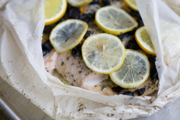 This Dec. 2, 2013 photo shows salmon baked in a bag with citrus, olive and chilies in Concord, N.H. The bag keeps the flavor and moisture trapped inside during cooking, allowing the juices from the fish and the other ingredients to mingle and become a wonderful sauce. (AP Photo/Matthew Mead)