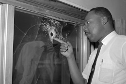 Integration leader Dr. Martin Luther King looks at a glass door of his rented beach cottage in St. Augustine, Fla. that was shot into by someone unknown on June 5, 1964.  King took time out from conferring with St. Augustine integration leaders to inspect the house, which no one was in at the time of the shooting.  (AP Photo/Jim Kerlin)